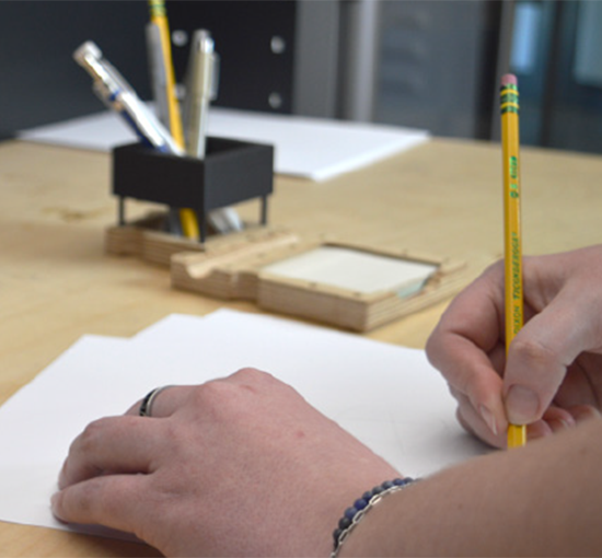 hands writing on paper with pencil