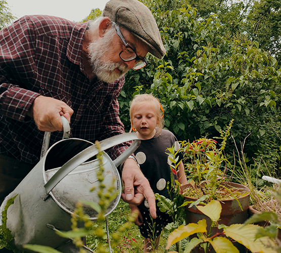 elderly man and child watering plants